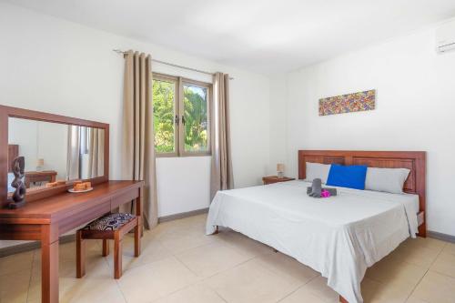 Un dormitorio con una cama, un escritorio y un espejo. en Casa Martello by IHR, en Rivière Noire