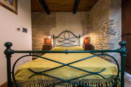 a bedroom with a metal bed in a stone wall at il sogno di Tino in Cabernardi