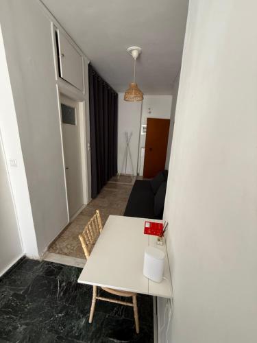 a living room with a white table and a couch at Cósy apartment in Palaiá Fókaia