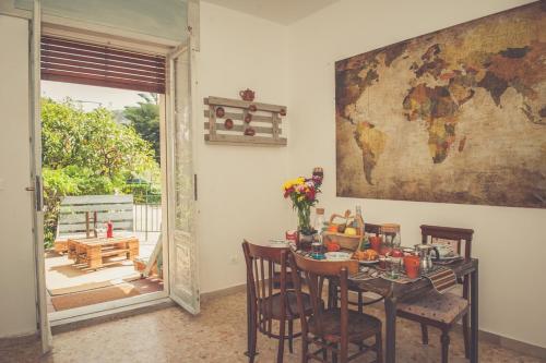 a dining room with a table and a map on the wall at Nomad B&B in Gaeta