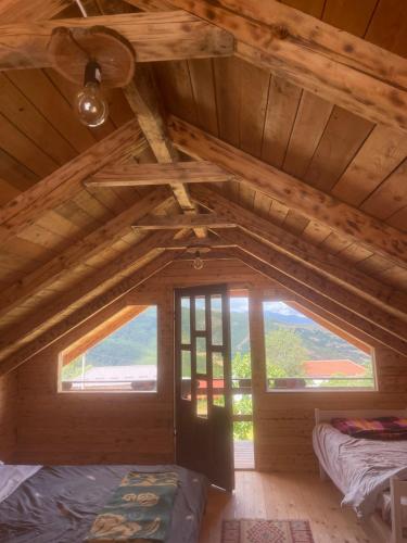 a room with two beds in a wooden attic at Shpia e Las Vol in Vasije
