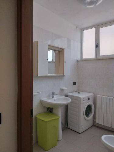 a bathroom with a sink and a washing machine at Casa Martini in Lido degli Estensi
