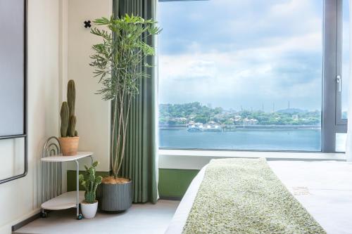 a living room with a large window with plants at 茑岛海景潮宿NiaoDao Seaview Hotel in Xiamen