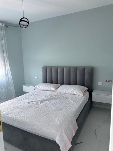 a bedroom with a large bed with a gray headboard at Avela Escape Apartments in Polisi i Vogël