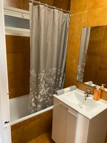 a bathroom with a sink and a shower curtain at De Palacio in Logroño