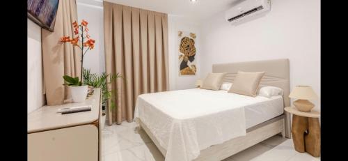 a white bedroom with a bed and a television at Azure Bliss in Costa de Adeje
