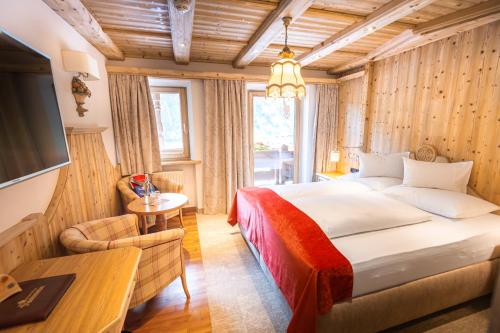 a bedroom with a large bed and a television at Hotel Neuhintertux 4 Sterne superior in Tux
