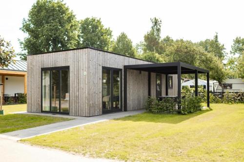 a modern house with a black roof at Recreatiepark de Markplas in Opheusden