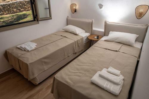 a room with two beds and a table and a window at Casa del mare in Pýrgos