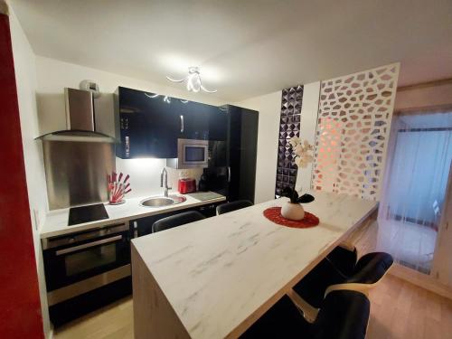 une cuisine avec une table et un comptoir dans l'établissement Le Petit Versailles, à Franconville