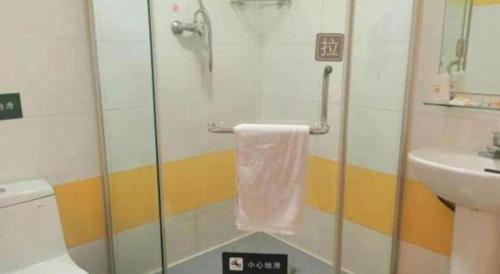 a bathroom with a glass shower with a towel at 7 Days Inn Changchun Zhengyang Street Changchun Park Branch in Changchun