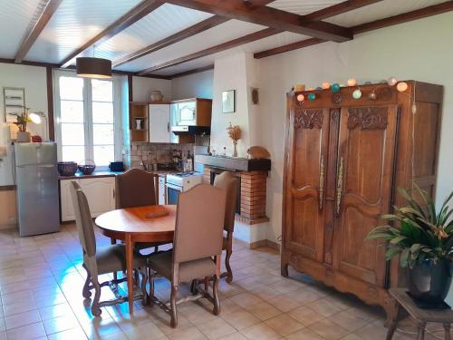 a kitchen with a wooden table and a dining room at Maison de Campagne in Treffléan