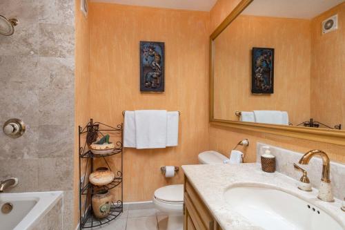 a bathroom with a sink and a toilet and a mirror at Wait 'n Sea Retreat Spacious Oceanfront Condo in Puerto Peñasco