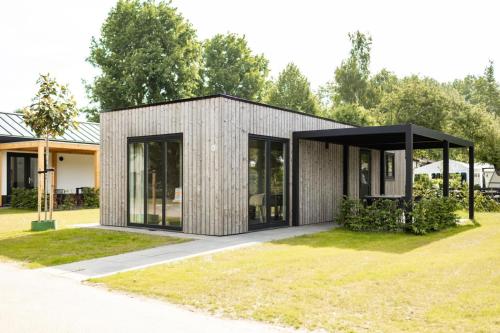 a gray house with a black roof at Recreatiepark de Markplas in Opheusden