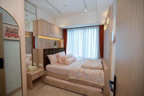 a bedroom with a bed and a large window at Podomoro City Deli Medan Tower Empire - Japandi Style - 2BR Family Suite 3 beds - 87m in Medan