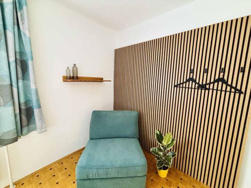 a blue chair and a plant in a room at Ferienwohnung Janisch in Mank