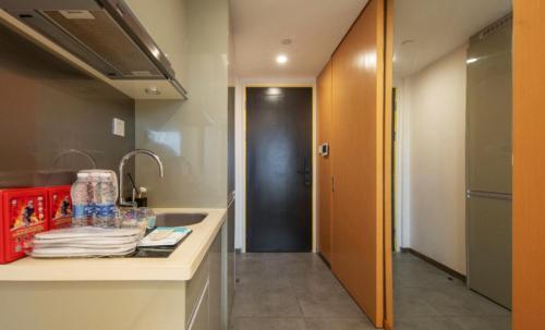 a bathroom with a sink and a hallway at Suyi Hotel Apartment in Sha-ho-p'u