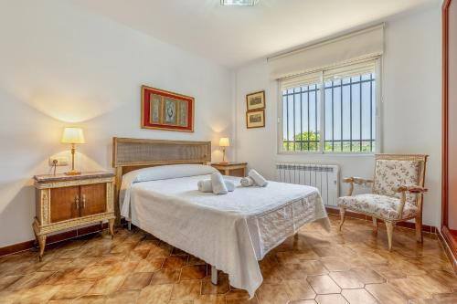 a bedroom with a bed and a chair and a window at Huerto del Carmen in Santa Fe