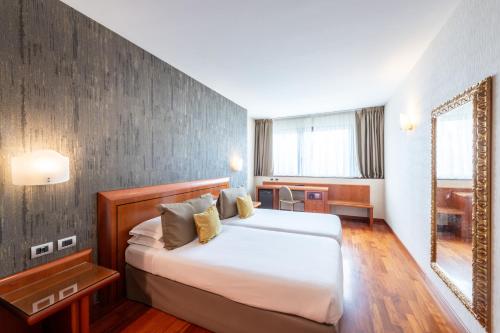 a hotel room with a bed and a mirror at Hotel Palace Verona in Verona