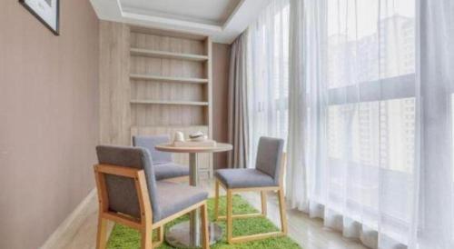 a room with two chairs and a table and a window at Atour Hotel Xi'an High Tech Dazhai Road in Xi'an