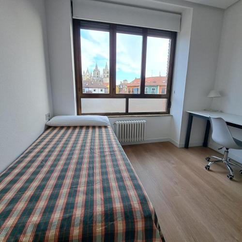 a bedroom with a bed and a large window at Miresileón in León