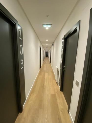 a long hallway with two doors and a wooden floor at Miresileón in León