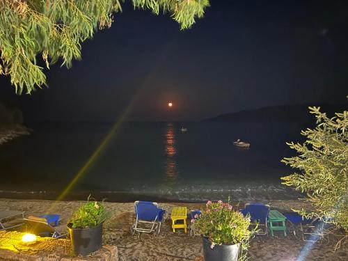 a group of chairs on the beach at night at Dimitris room kamares 2 in Kamáres