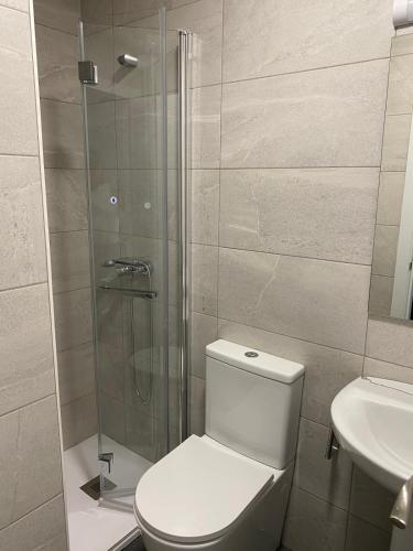 a bathroom with a toilet and a glass shower at Miresileón in León
