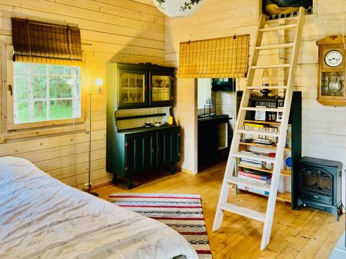 Un dormitorio con escalera y una cocina con estufa. en Niiduliiva Holiday Home, en Nasva