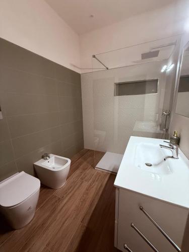 a bathroom with a toilet and a bidet and a sink at Stagnone Sunset Holidays in Marsala