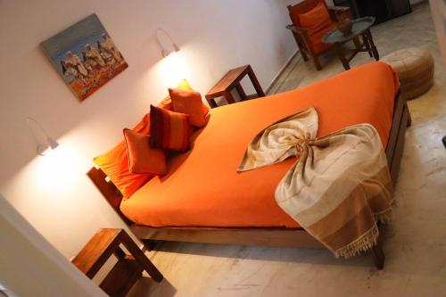 an orange couch in a living room with lights at Riad Dar Latigeo in Essaouira