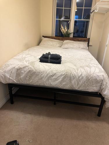 a bed in a bedroom with a black bag on it at Private Room in a shared flat with own Bathroom and Parking in West Bromwich