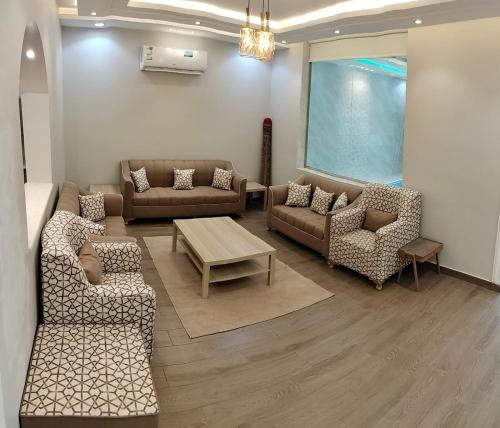 a living room with couches and chairs and a table at فلل الكناري in Taif