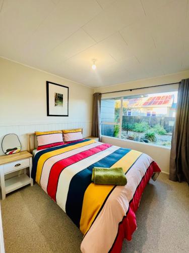 a bedroom with a large bed and a window at The Crossing Retreat in Turangi
