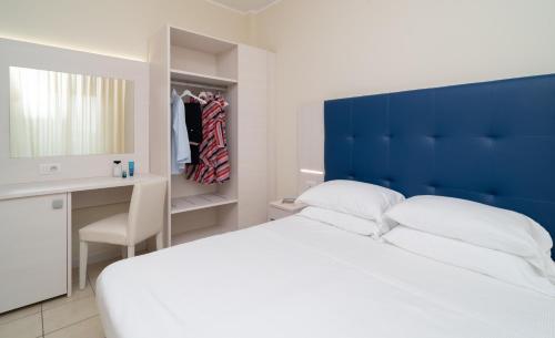 a bedroom with a large bed with a blue headboard at Hotel Riviera in Porto San Giorgio
