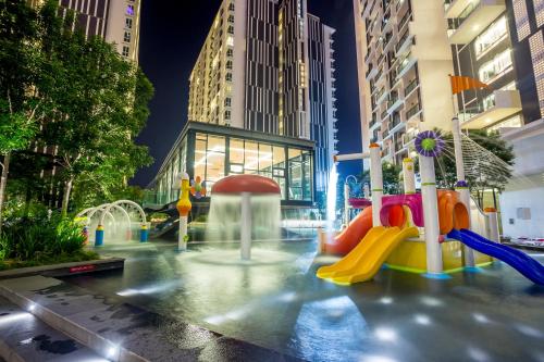 un parque infantil en una ciudad por la noche con edificios en The Shore Hotel & Residences en Melaka