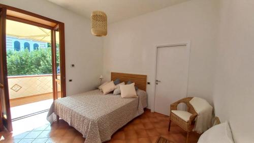 Un dormitorio con una cama y una silla y una ventana. en Borgo P Palazzo Catone, en Cava deʼ Tirreni
