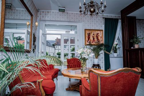 a living room with a table and red chairs at Hotel Nysa in Nysa