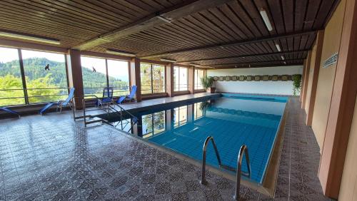 a large swimming pool with chairs in a building at Haus Norea, Top 65 in Sankt Urban