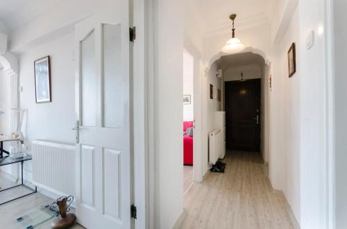 un couloir avec des murs blancs et une porte blanche et un couloir avec une longueur de couloir dans l'établissement Windows On The Bay - izmir, à Konak