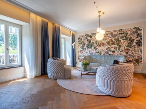 a living room with two chairs and a table at Steigenberger Icon Europäischer Hof Baden Baden in Baden-Baden