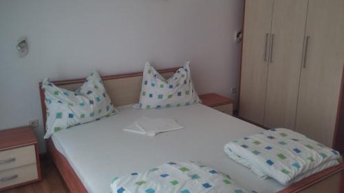 a small bedroom with a white bed with pillows at Apartments Turkalj in Murter