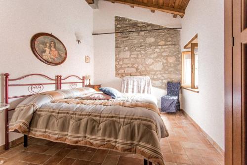 a bedroom with a large bed and a stone wall at Agriturismo La Calamaia in Gorfigliano