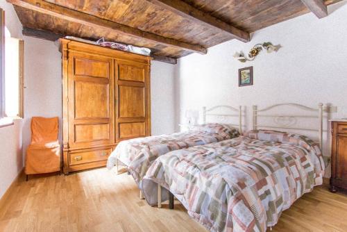 a bedroom with a bed and a wooden cabinet at Agriturismo La Calamaia in Gorfigliano
