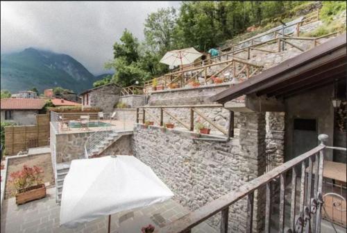 a balcony with a white umbrella and a building at Agriturismo La Calamaia in Gorfigliano