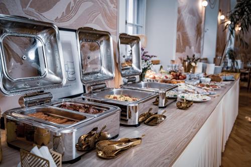 a buffet line with several trays of food at Hotel Nysa in Nysa