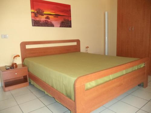 una camera con un letto con telaio in legno e un tavolo di Casa del Marinaio 150 mt spiaggia Marangi a San Foca