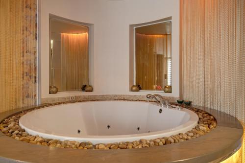 a large bath tub in a bathroom with rocks around it at SPA apartments in city centre in Vilnius
