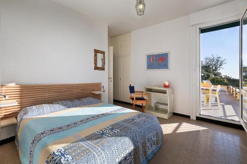 a bedroom with a bed and a desk and a balcony at Villa Ornella in Cavi di Lavagna