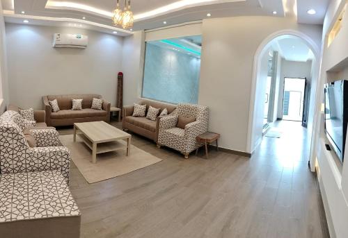 a living room with couches and chairs and a table at فلل الكناري in Taif